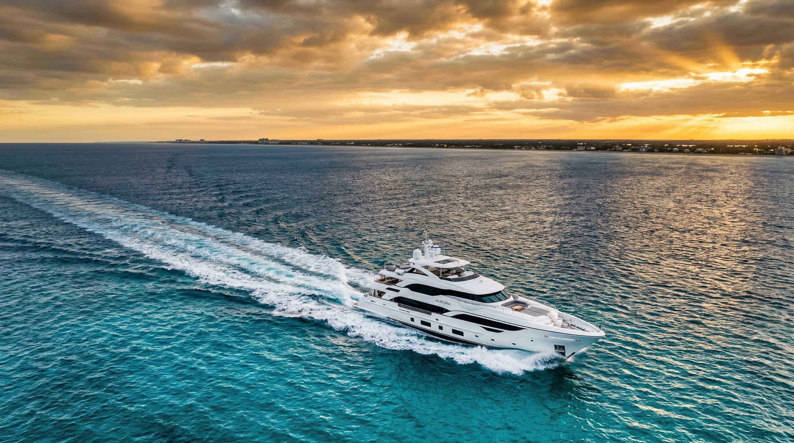 Yacht navigating turquoise ocean waters at golden hour